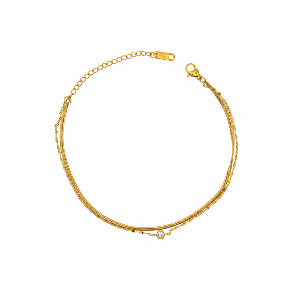 Brățară de picior aurie, design minimalist și elegant din 2 randuri de lant unul sarpe si unul sibtire cu o pietricica in mijloc.