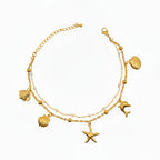 Brățară de picior fină și strălucitoare, perfectă pentru vară, din 2 lanturi, 1 cu mici bilute albe tip perle si unul cu charmuri in forma de stea de mare, peste, scoica, delfin.