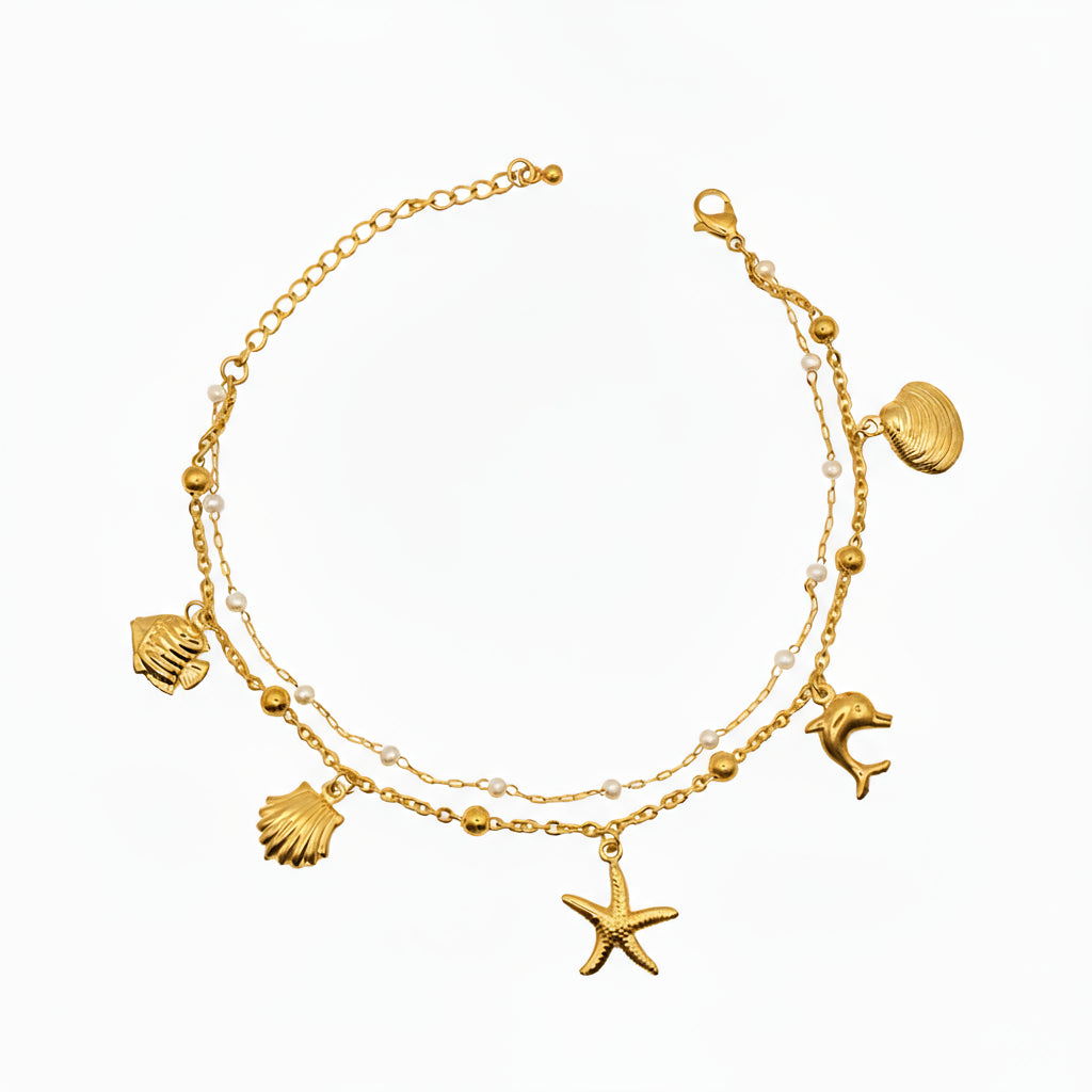 Brățară de picior fină și strălucitoare, perfectă pentru vară, din 2 lanturi, 1 cu mici bilute albe tip perle si unul cu charmuri in forma de stea de mare, peste, scoica, delfin.