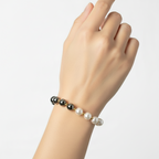 Brățară pe elastic cu bile albe și argintii mari si margele mici aurii care desparte margelele mari