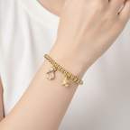 Brățară pe elastic cu bile aurii și charm cu ursulet si stea de mare