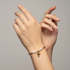 Brățară pe elastic cu bile albe și aurii și charm cruciulita cu pietre negre