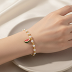 Brățară pe elastic cu bile albe și aurii și charm felie de pepene rosu