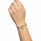 Brățară pe elastic cu bile albe și aurii și charm cruciulita cu pietre albe