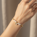 Brățară pe elastic cu bile albe și aurii și charm fluturas mic cu pietricele