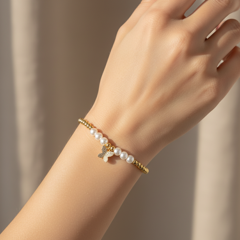 Brățară pe elastic cu bile albe și aurii și charm fluturas mic cu pietricele